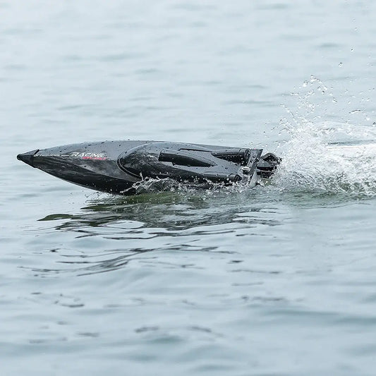 RC Speed Boat 2.4G 4WD 55KMH speeding through water with splashes, showcasing its sleek design and performance.