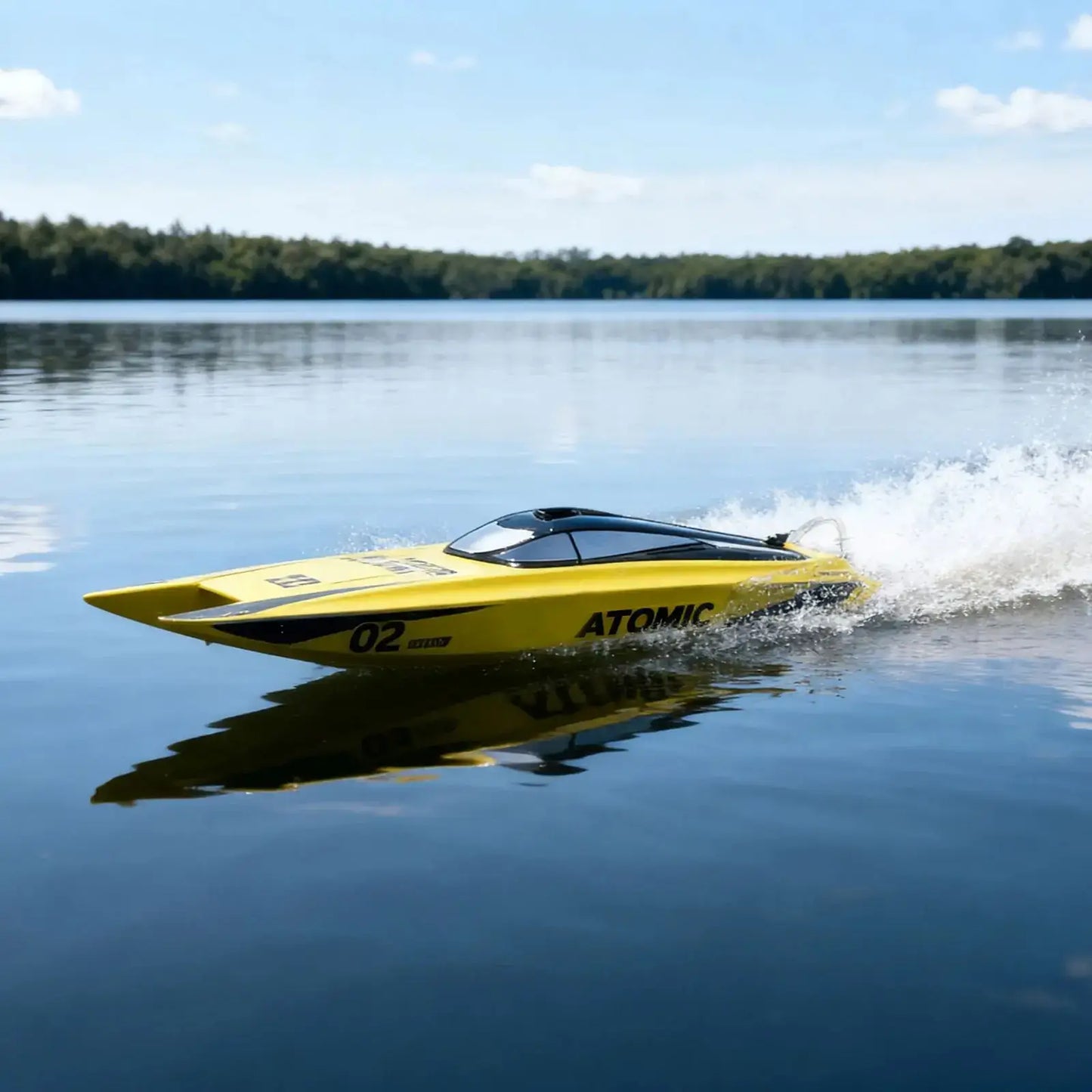 Large Remote Control Boat speeding across a serene lake, showcasing the Atomic SR65B design.