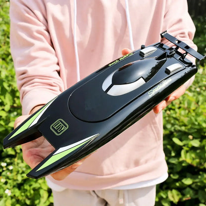 Person holding an RC Boat 2.4Ghz 25kmh high-speed remote control racing ship in a sunny outdoor setting.