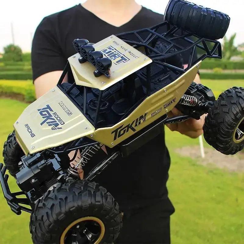RC Car Remote Control Climbing Vehicle being held outdoors on a sunny day, showcasing its rugged all-terrain design.