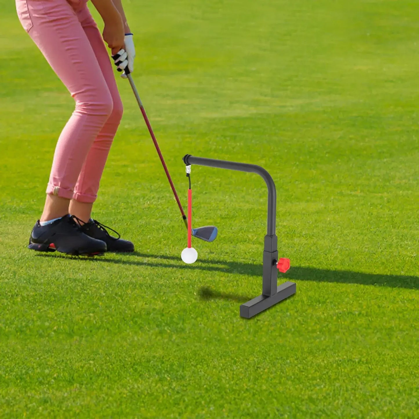 Golf Swing Trainer in use, demonstrating swing practice with golf ball on the grass.