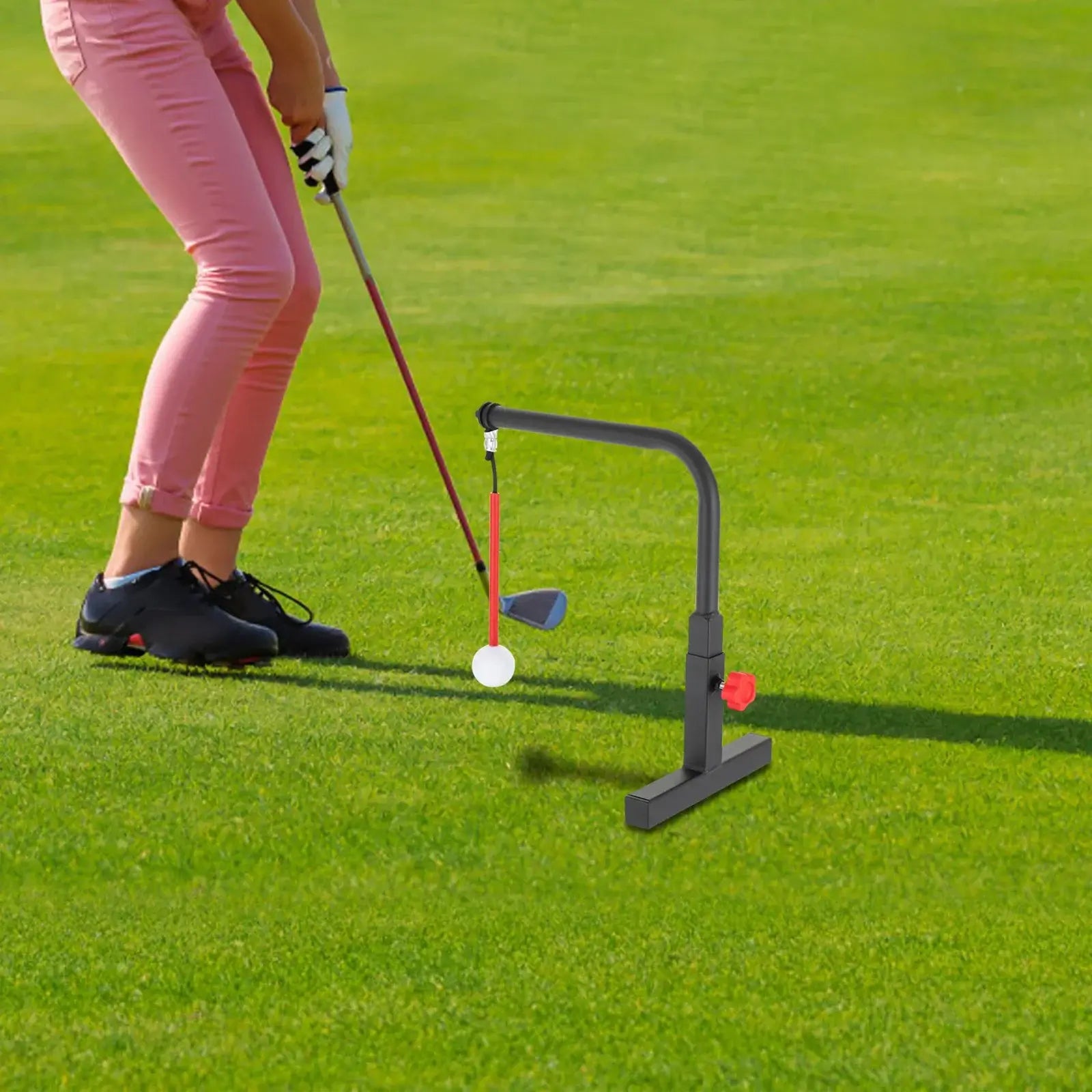 Golf Swing Trainer in use, demonstrating swing practice with golf ball on the grass.