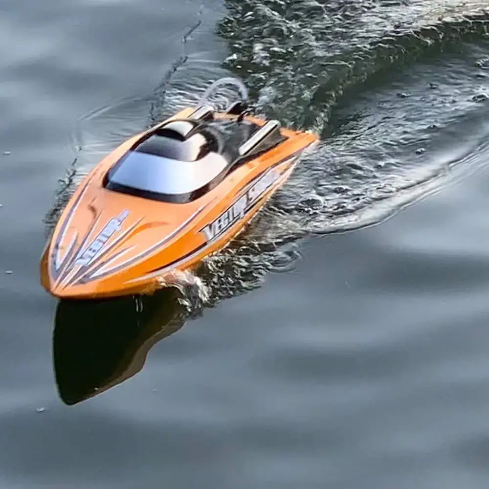 SR80 Pro. RTR 31.5 RC Boat zooming across the water surface in bright orange color.