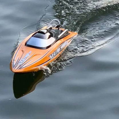 SR80 Pro. RTR 31.5 RC Boat zooming across the water surface in bright orange color.
