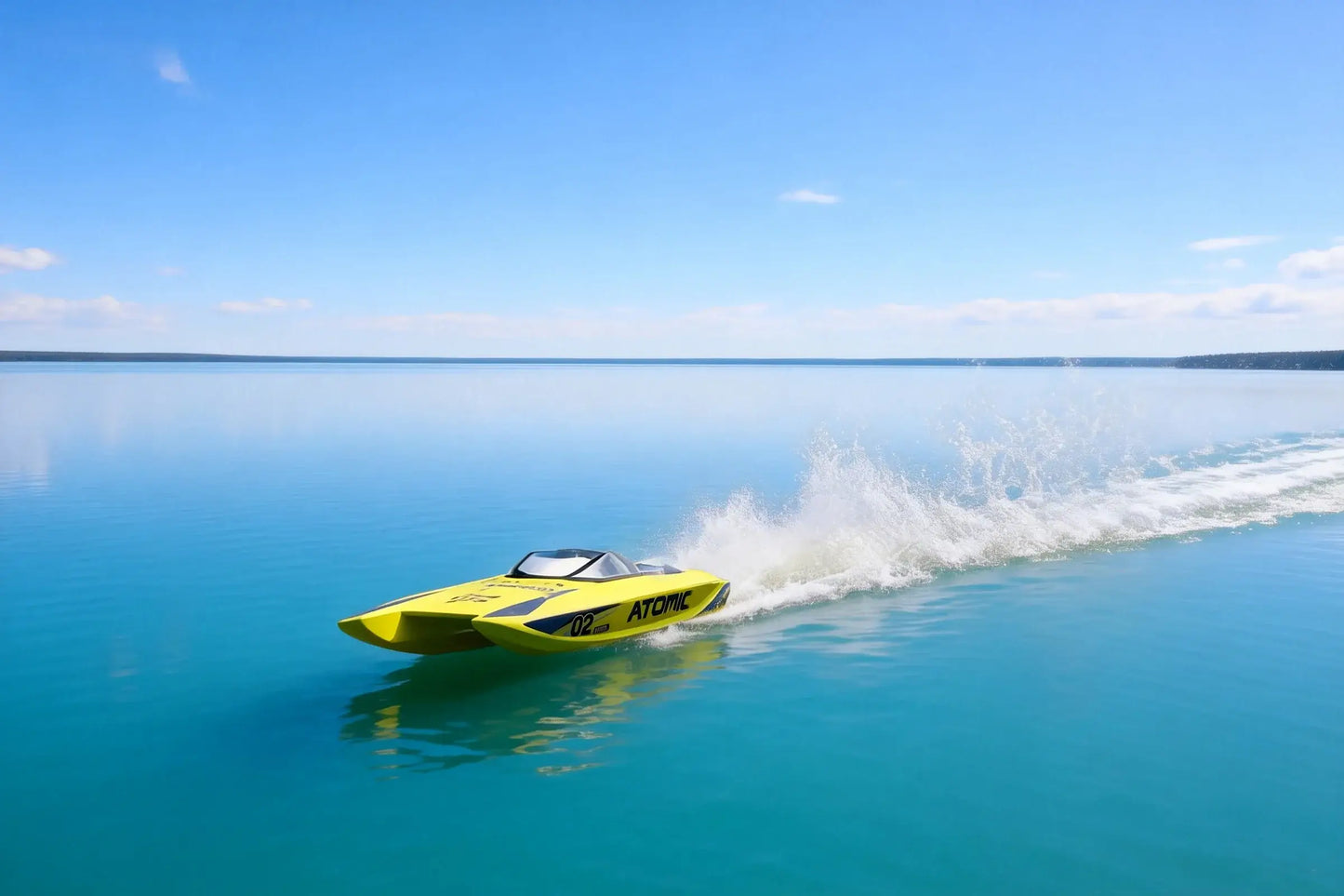 Large Remote Control Boat speeding across clear blue water with a splash in the background.