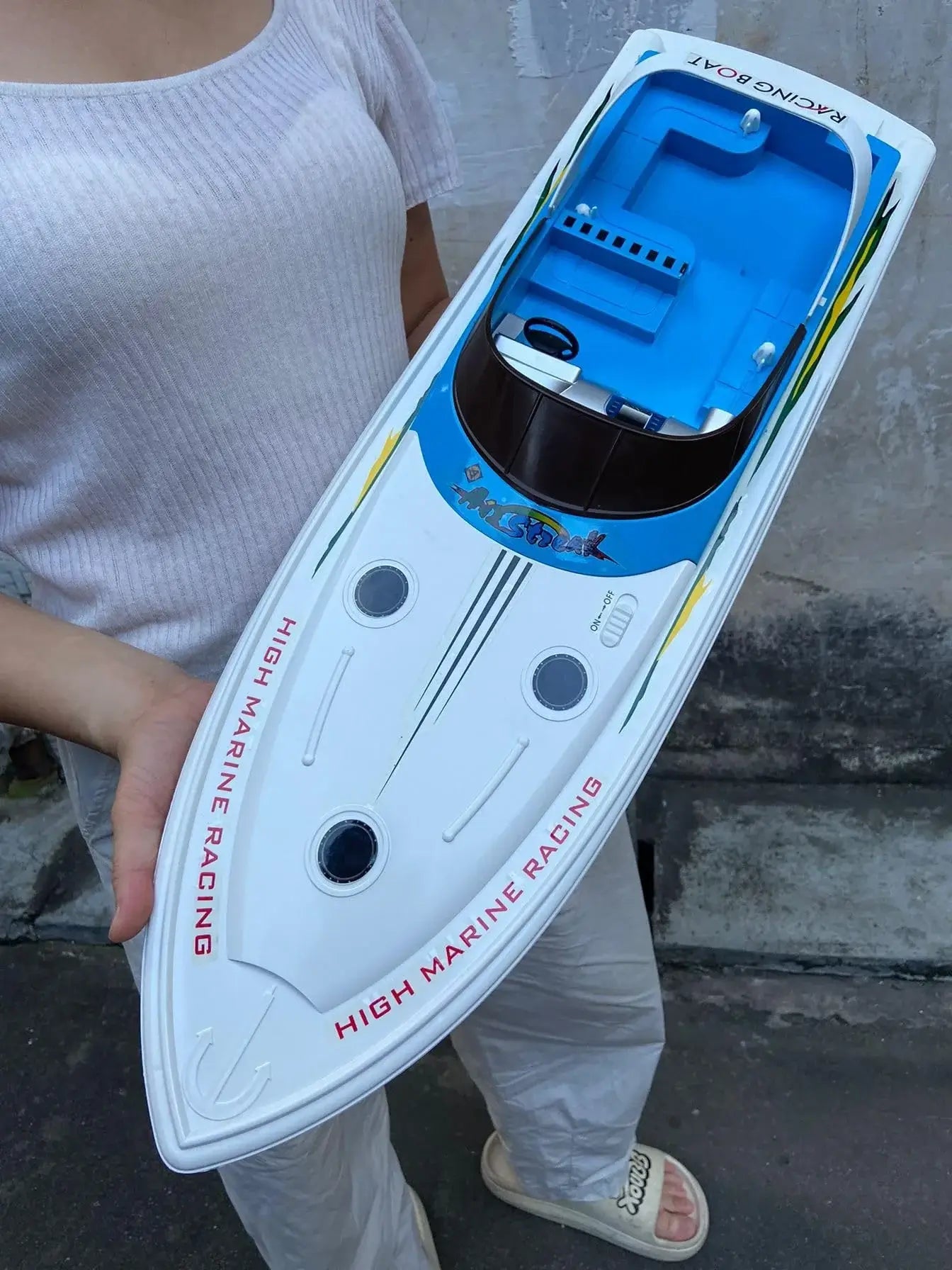 Super large remote control yacht held by a person, showcasing its sleek design and features for outdoor lakes.