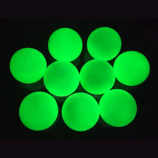 Glowing Golf Ball For Night Training glowing green balls arranged together in a dark setting.