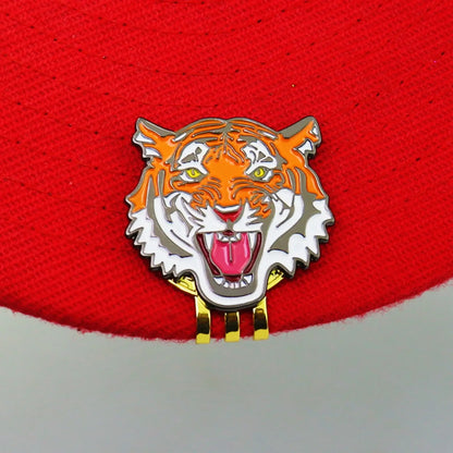 vibrant tiger head design golf ball marker hat clip attached to a red hat, perfect for golf enthusiasts