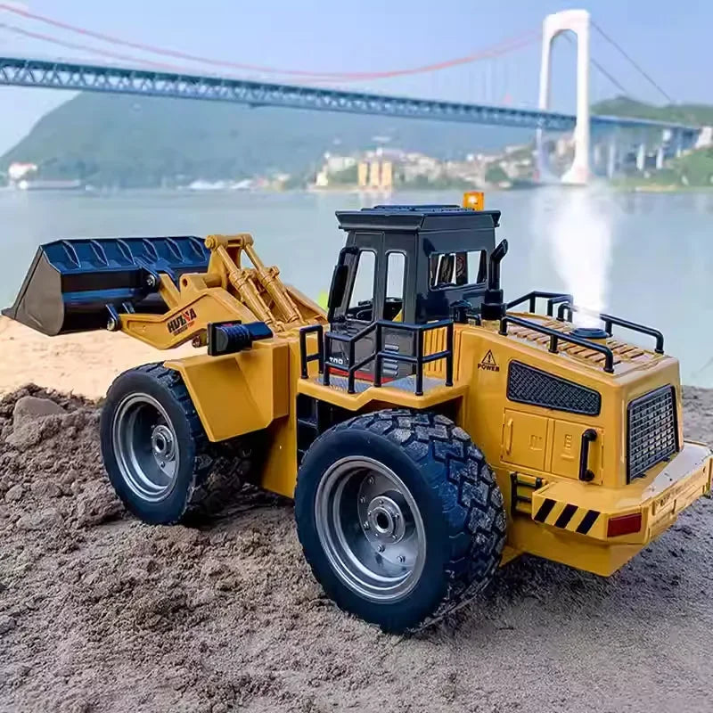 HUINA 1560 RC bulldozer on sandy terrain with a bridge in the background, showcasing its detailed design and robust construction.